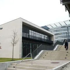 Moderne Architektur der FernUniversität in Hagen. Ein Mann steigt die Treppen hinauf.
