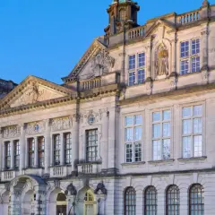 Prachtvolles Gebäude einer **Uni England** mit vielen Fenstern und architektonischen Details, beleuchtet im Abendlicht.