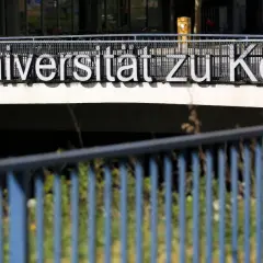 Großbuchstaben "Universität zu Köln" auf einem Geländer. Eine Hochschule ist eine Uni, ein Ort des Lernens.