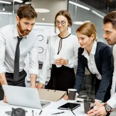 Team bespricht wichtige Aspekte des Wirtschaftsrechts am Laptop.