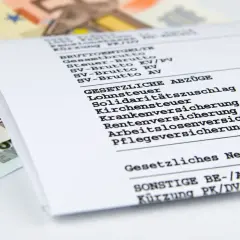 Gehaltsabrechnung mit Euro-Scheinen. Ein Blick auf das gesetzliche Netto zeigt, was nach Abzügen für einen Job in der Lagerlogistik übrig bleibt.