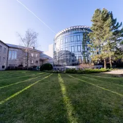 Moderne Architektur mit Glasfassade und einem älteren Gebäude, umgeben von Grünflächen. Hier wird msb psychologie gelebt und geforscht.