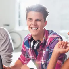 Junge Leute lachen und arbeiten zusammen. Die **Berufsgruppen Tabelle** könnte hier als Inspiration für ihre zukünftigen Karrieren dienen.