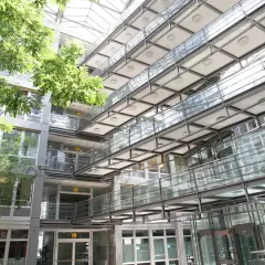 Moderne Architektur mit Glasbrücken und viel Grün im Innenhof der Hochschule Stuttgart.