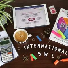 Lernmaterialien für BWL: Buch, Tablet mit Notizen, Taschenrechner, Kaffee und Stifte. Ein Crashkurs für BWL Bachelor of Science oder Arts.