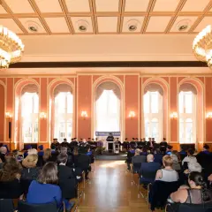 Absolventen der Touro University Berlin feiern ihren Abschluss in einem prunkvollen Saal mit Kronleuchtern.