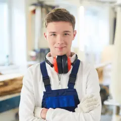Junger Mann in Werkstatt, bereit für die Elektroniker Ausbildung. Das Gehalt netto ist ein wichtiger Faktor für die Berufswahl.
