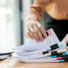 Hände sortieren Dokumente. Die Ausbildung zum Justizfachwirt und das Gehalt sind wichtige Aspekte für angehende Juristen.