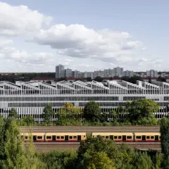Moderne Architektur der Berlin School of Arts mit Zug davor.