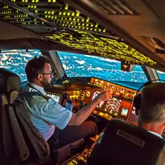 Zwei Piloten im Cockpit bei Nachtflug. Die Frage, wie viel verdient ein Pilot im Monat, beschäftigt viele.