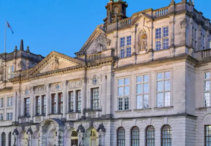 Prachtvolles Gebäude einer **Uni England** mit vielen Fenstern und architektonischen Details, beleuchtet im Abendlicht.