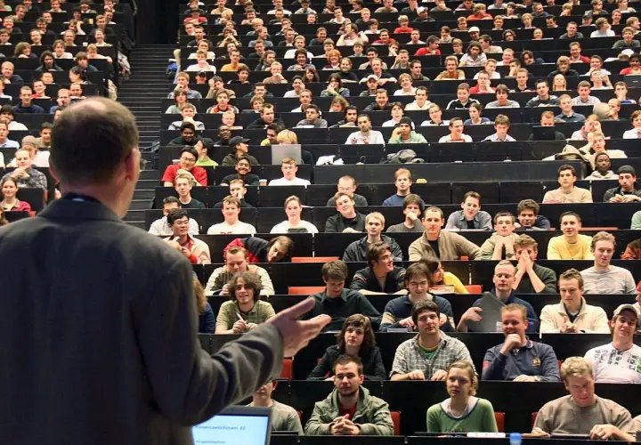 Dozenten sprechen vor vielen Studenten in einem Hörsaal. Einer von ihnen ist ein Bachelor-Ingenieur, der hier lernt.