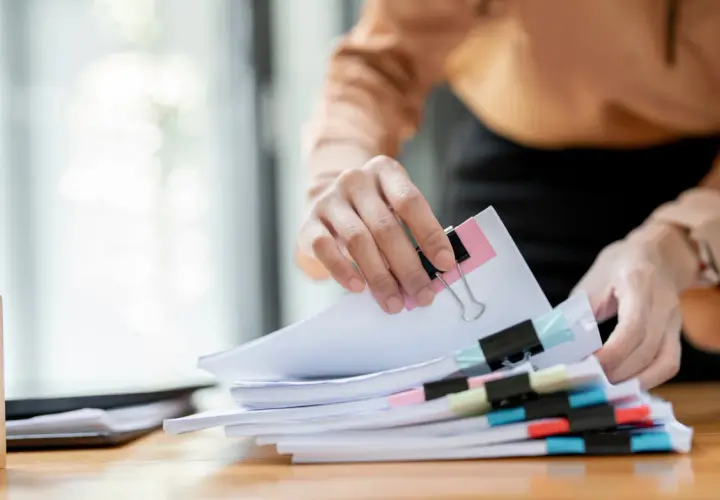 Hände sortieren Dokumente. Die Ausbildung zum Justizfachwirt und das Gehalt sind wichtige Aspekte für angehende Juristen.
