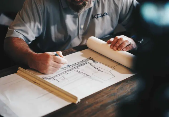 Architekt skizziert Entwurf. Die Dauer des Architekturstudiums ist lang, aber die Arbeit daran ist lohnend.