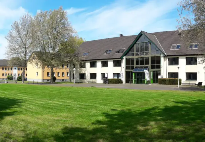 Grüne Rasenflächen und Gebäude der uni unna im Sonnenschein.
