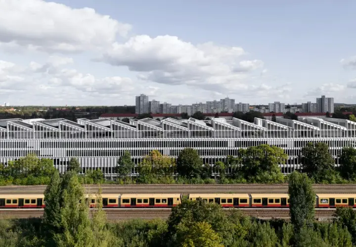 Moderne Architektur der Berlin School of Arts mit Zug davor.