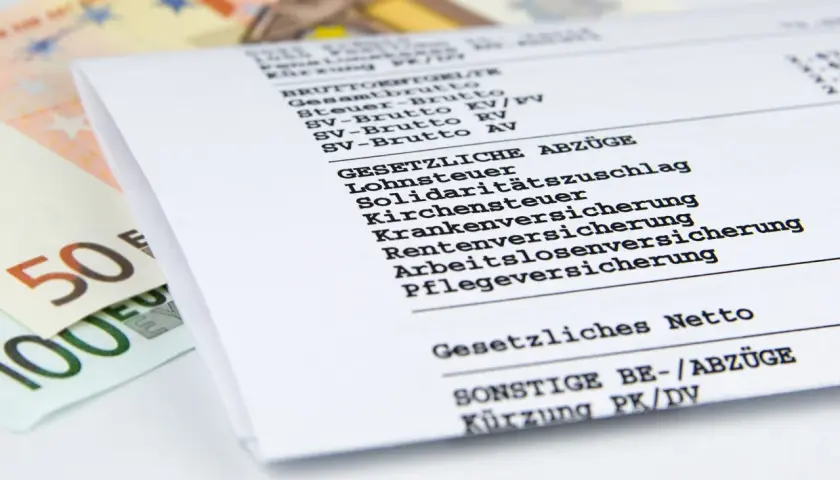 Gehaltsabrechnung mit Euro-Scheinen. Ein Blick auf das gesetzliche Netto zeigt, was nach Abzügen für einen Job in der Lagerlogistik übrig bleibt.