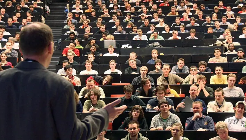 Dozenten sprechen vor vielen Studenten in einem Hörsaal. Einer von ihnen ist ein Bachelor-Ingenieur, der hier lernt.