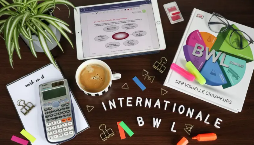 Lernmaterialien für BWL: Buch, Tablet mit Notizen, Taschenrechner, Kaffee und Stifte. Ein Crashkurs für BWL Bachelor of Science oder Arts.