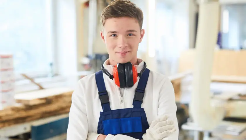 Junger Mann in Werkstatt, bereit für die Elektroniker Ausbildung. Das Gehalt netto ist ein wichtiger Faktor für die Berufswahl.