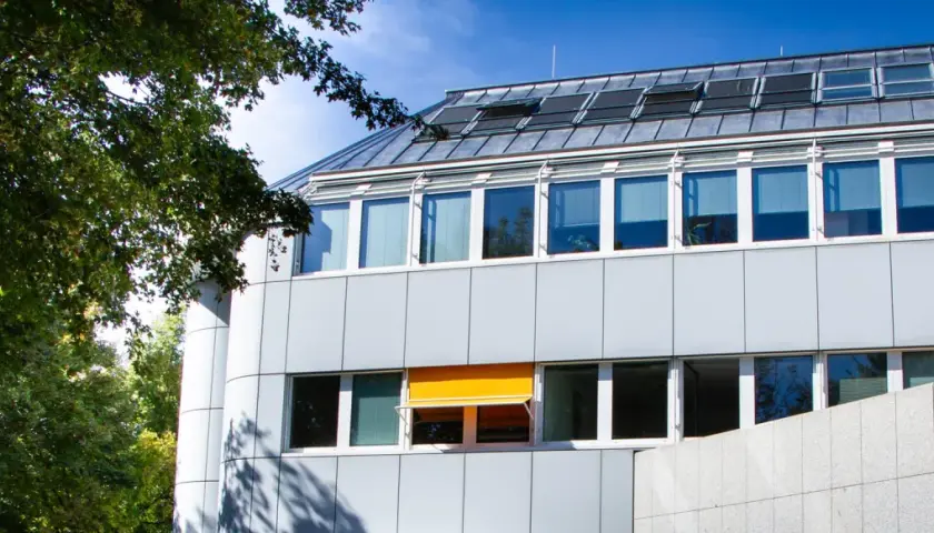Modernes Gebäude mit vielen Fenstern und einem ausfahrbaren Sonnenschutz in Ismaning.