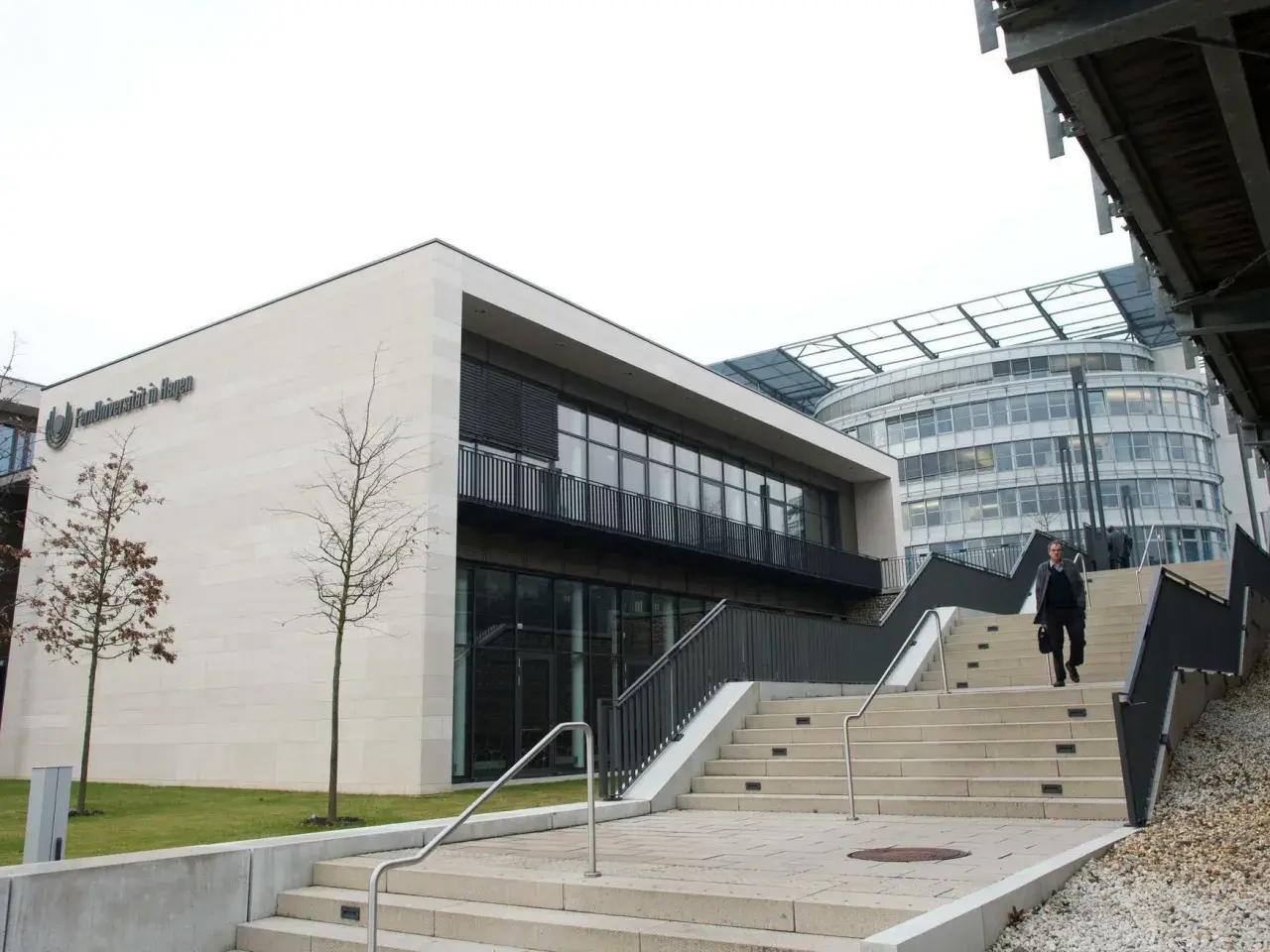 Moderne Architektur der FernUniversität in Hagen. Ein Mann steigt die Treppen hinauf.