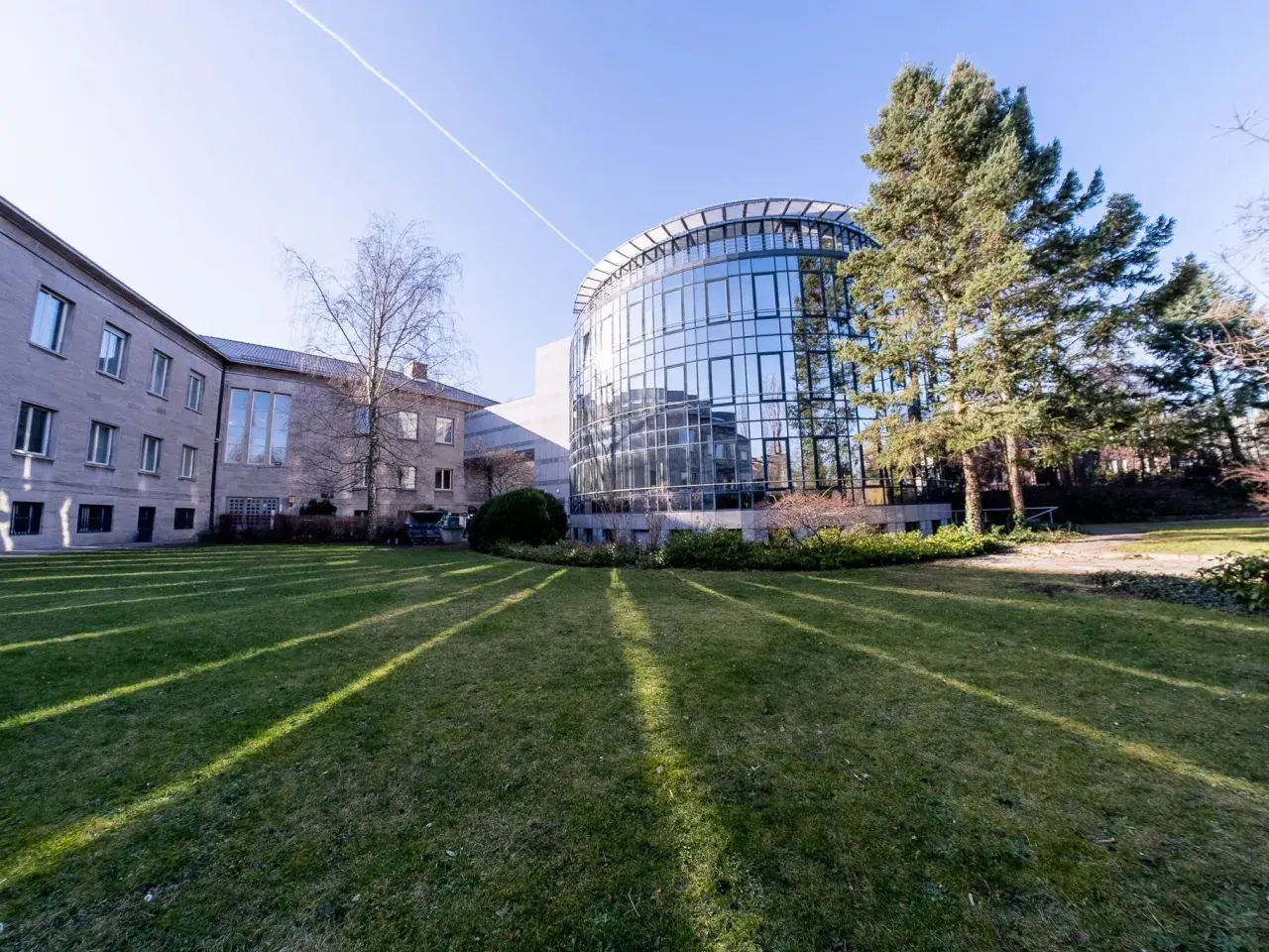 Moderne Architektur mit Glasfassade und einem älteren Gebäude, umgeben von Grünflächen. Hier wird msb psychologie gelebt und geforscht.