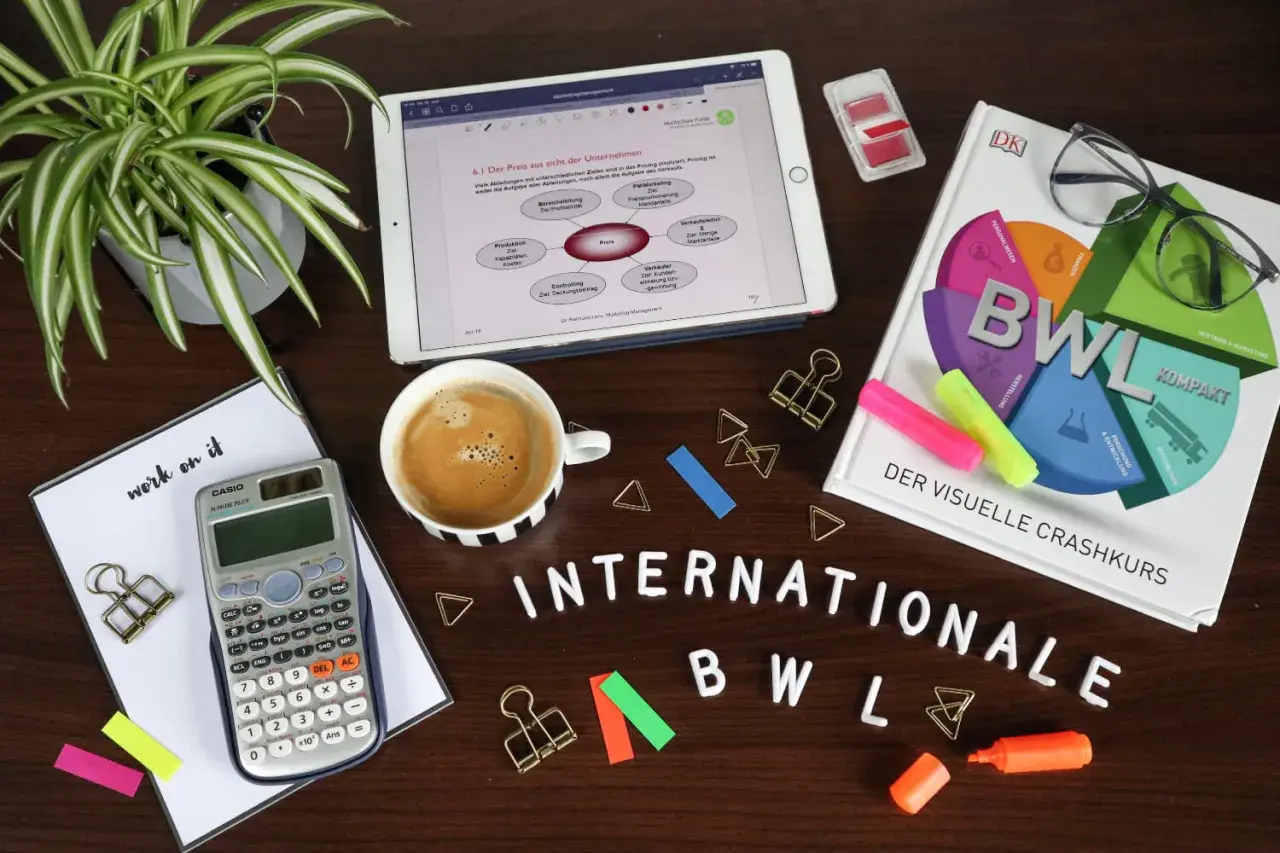 Lernmaterialien für BWL: Buch, Tablet mit Notizen, Taschenrechner, Kaffee und Stifte. Ein Crashkurs für BWL Bachelor of Science oder Arts.