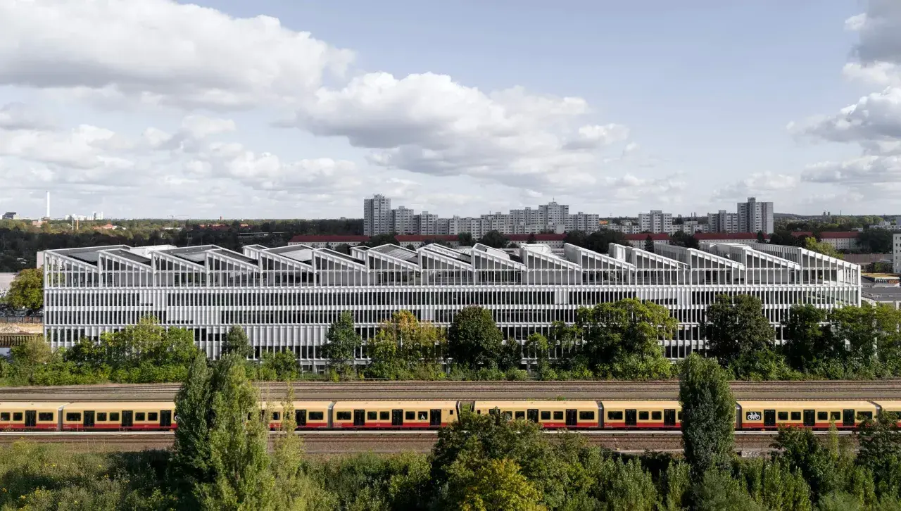 Moderne Architektur der Berlin School of Arts mit Zug davor.