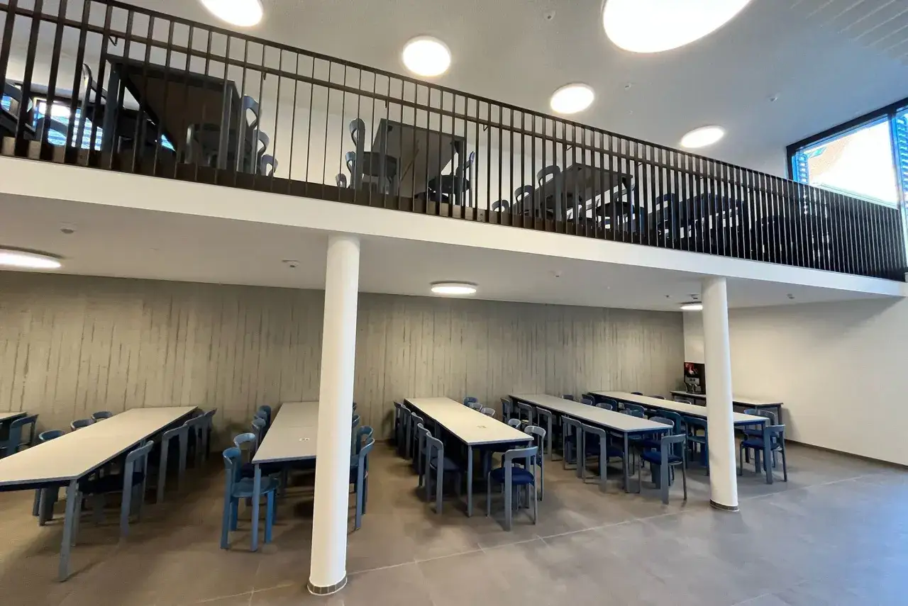 Moderne Mensa mit zwei Ebenen, Tischen und Stühlen. Ein Ort zum Lernen und Entspannen an der Nordhausen University.