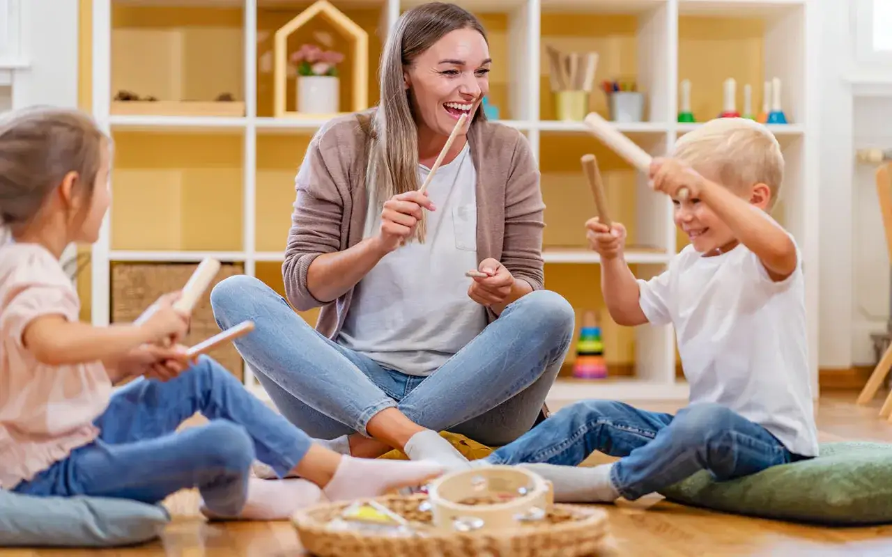 Lehrerin spielt mit Kindern Musik. Ein Beruf, der Freude bereitet und gut bezahlt wird, wenn man mit Kindern arbeitet.