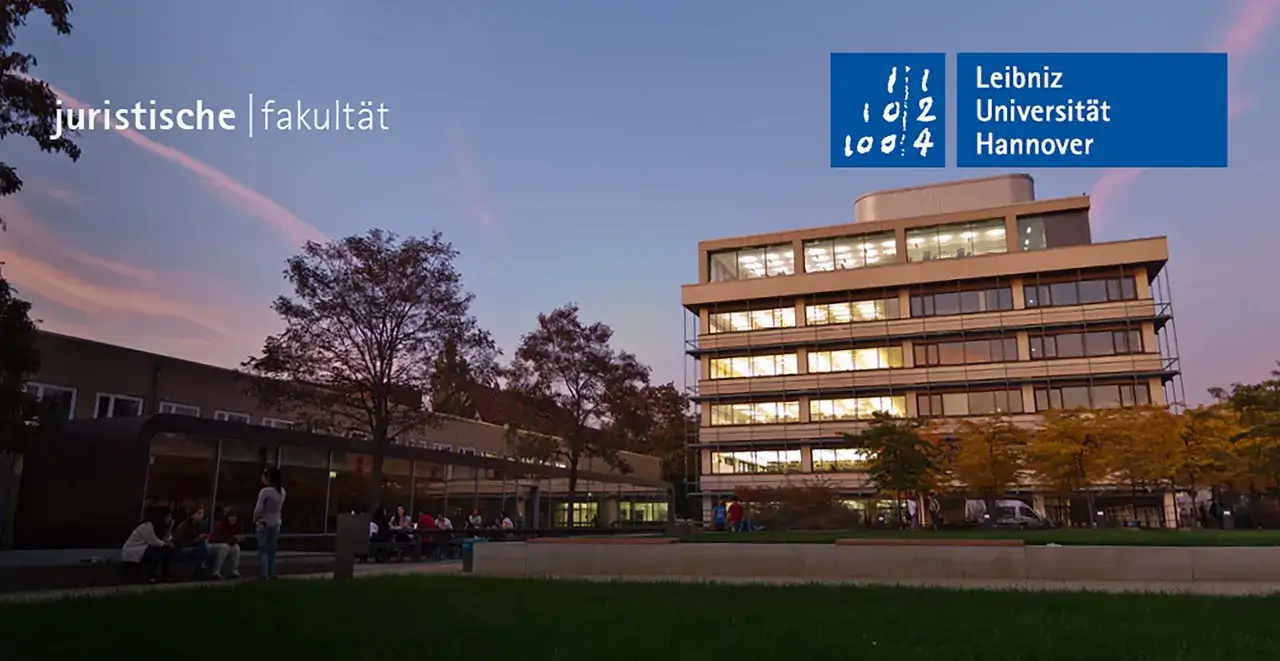 Abenddämmerung an der juristischen Fakultät der Leibniz Universität Hannover. Studierende sitzen vor dem Gebäude.