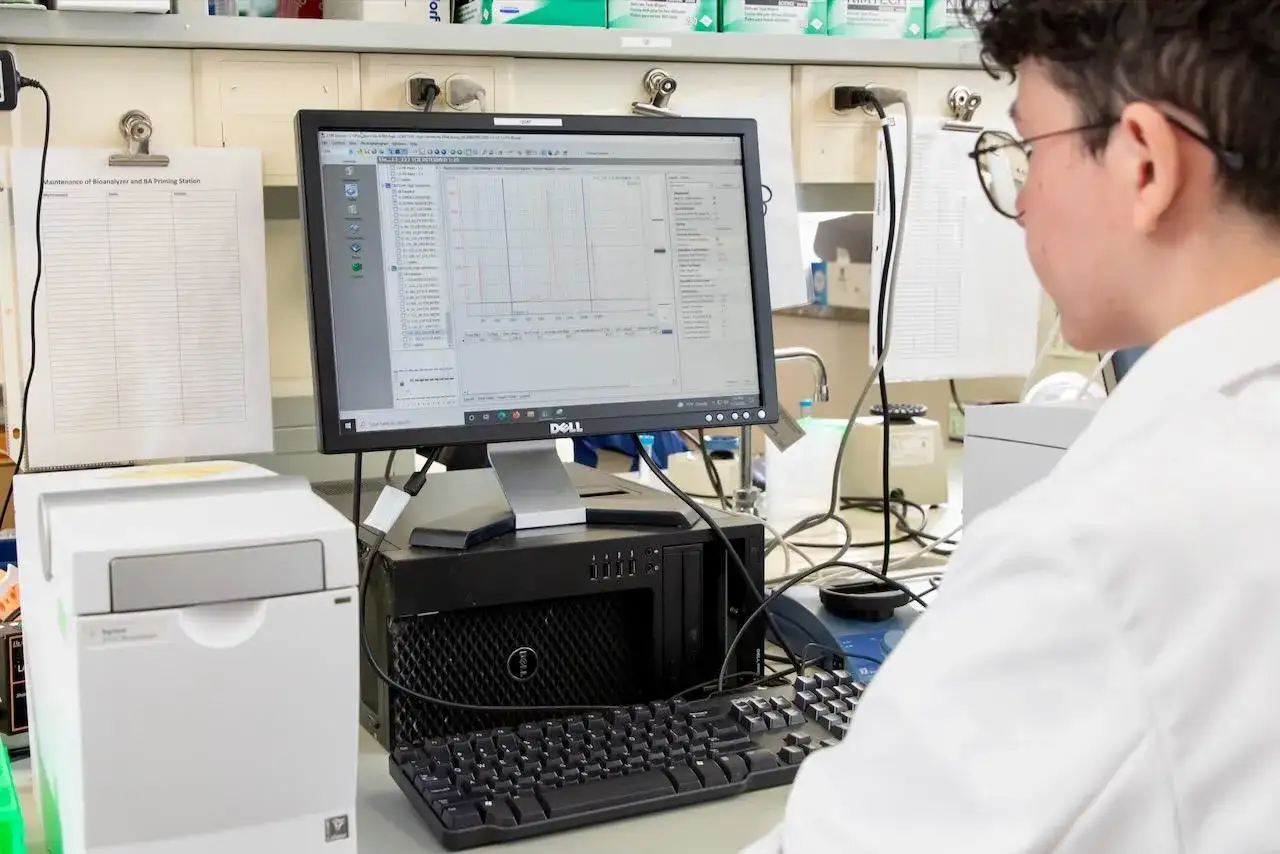 Ein Student im bioinformatik studium analysiert Daten auf einem Computer in einem Labor.