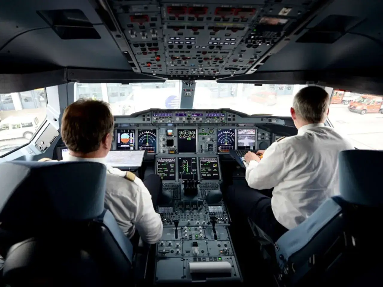 Zwei Piloten im Cockpit eines Flugzeugs, bereit zum Abflug. Die Frage, wie viel verdient ein Pilot im Monat, beschäftigt viele.