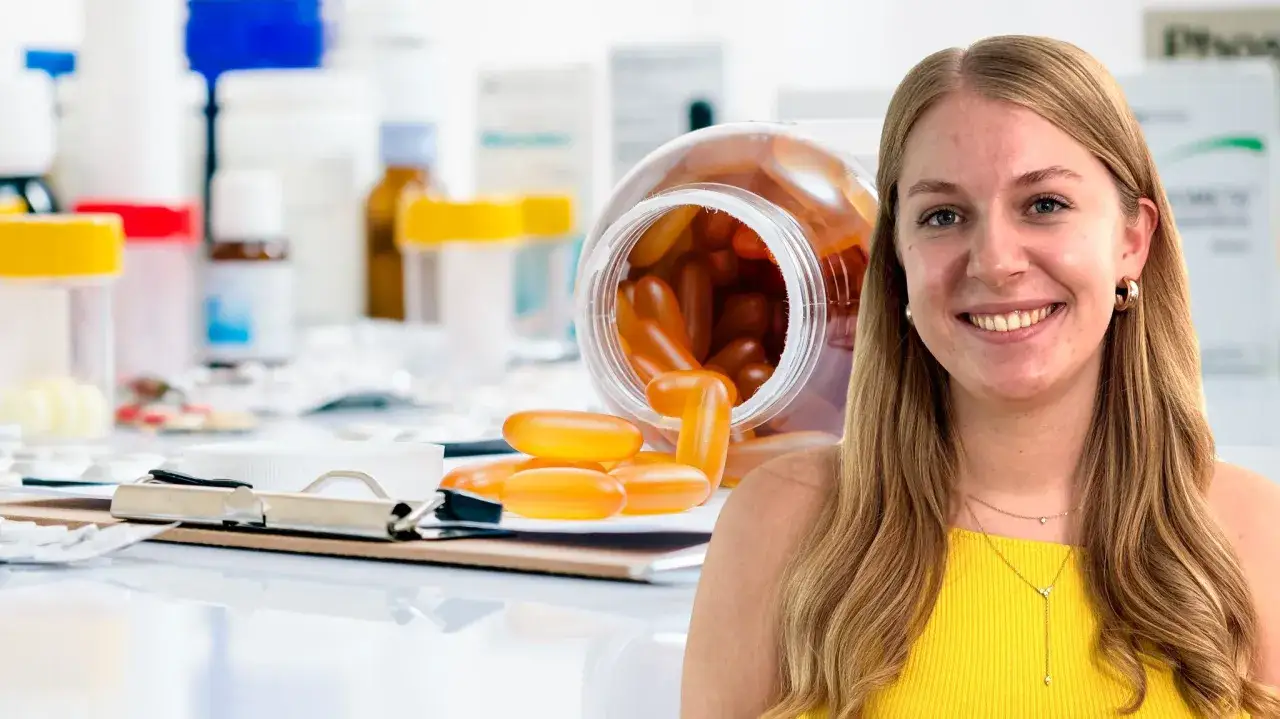 Junge Frau mit einem Lächeln, umgeben von Medikamenten und Pillen. Sie hat einen BSC-Abschluss und arbeitet in der Pharmaindustrie.