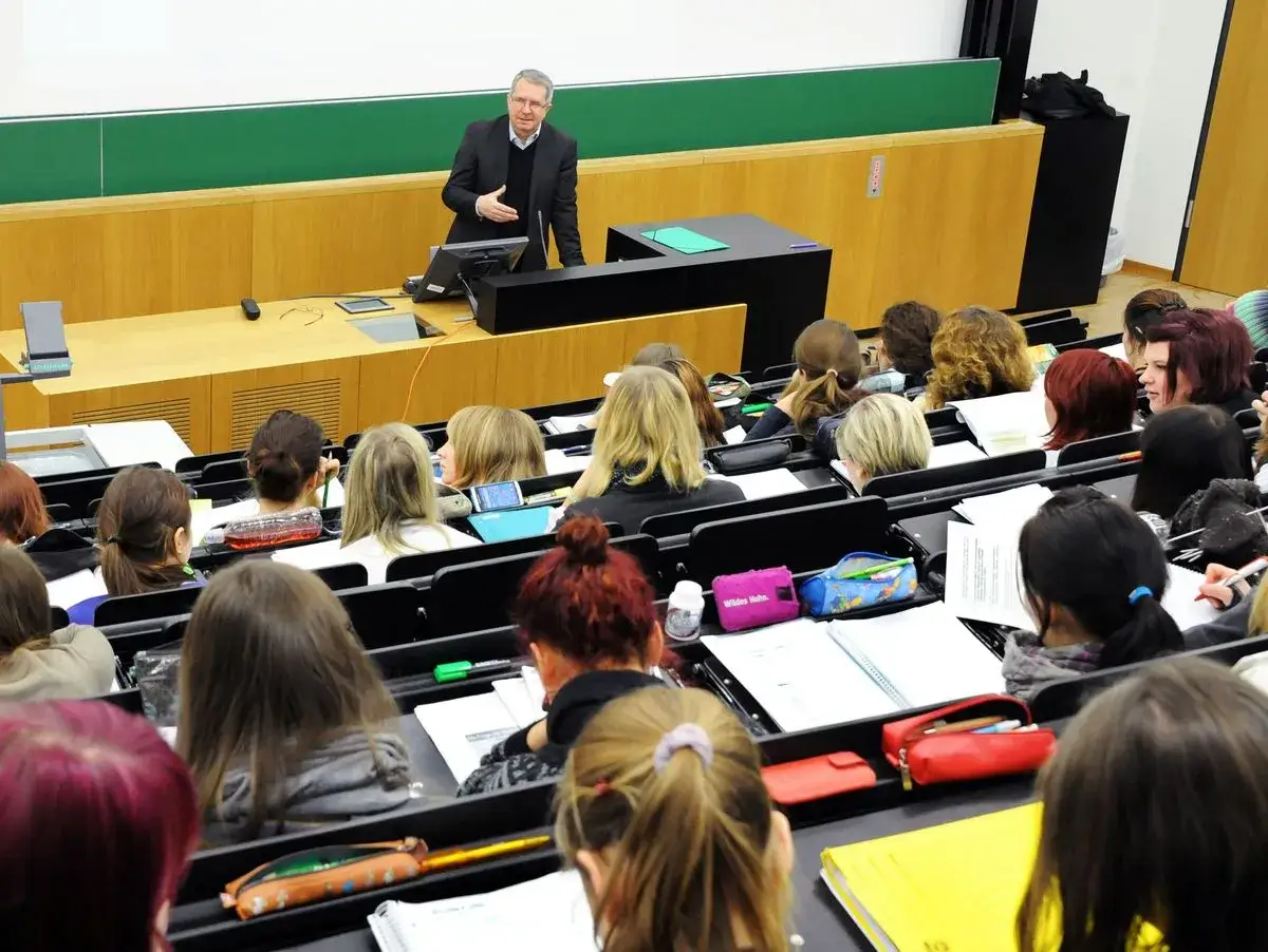 Dozent erklärt einer Studentengruppe, wie lange ein Lehramtsstudium dauert.